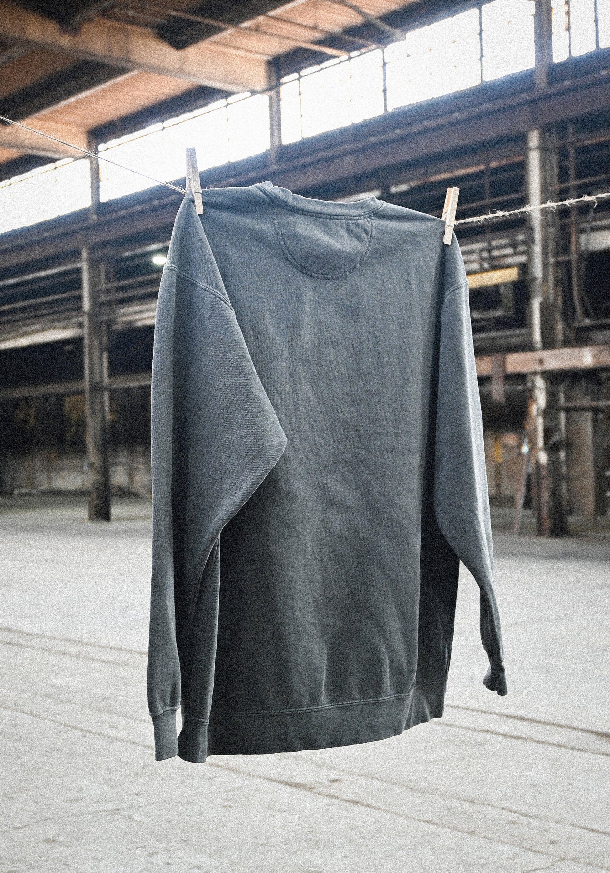 Fetch Boy Unisex Heavyweight Crewneck Sweatshirt in Steel Gray in Industrial Setting.