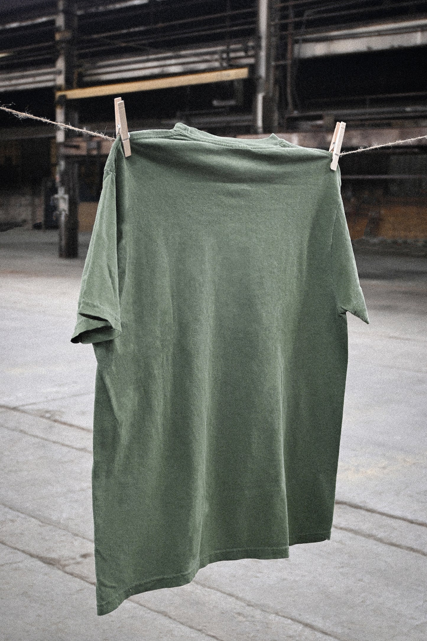 Fetch Boy Unisex Heavyweight T-Shirt in Moss in Industrial Vintage setting.